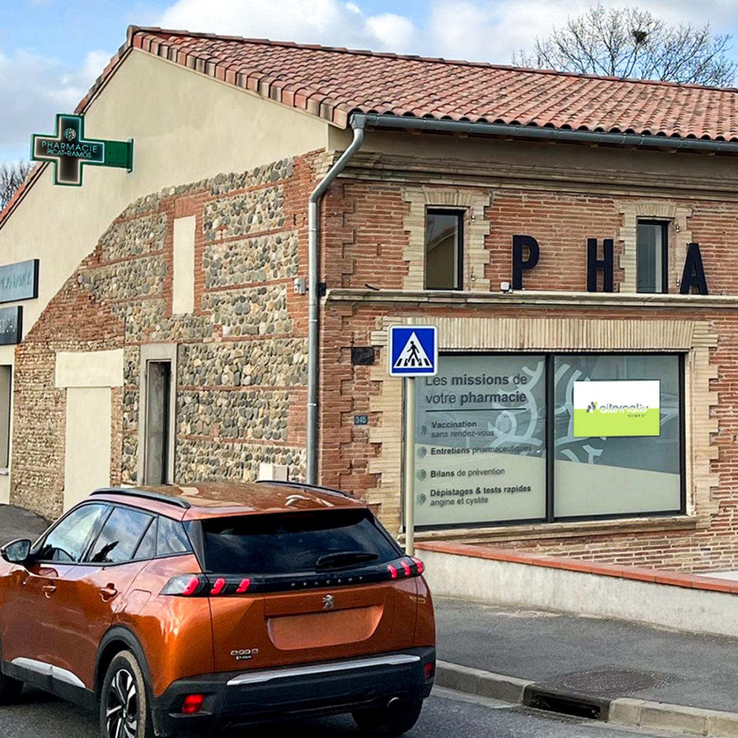 Vitrine digitale de la Pharmacie Picat Ramos à Fronton, avec croix LED double face et écran 55 pouces affichant messages et conseils santé.